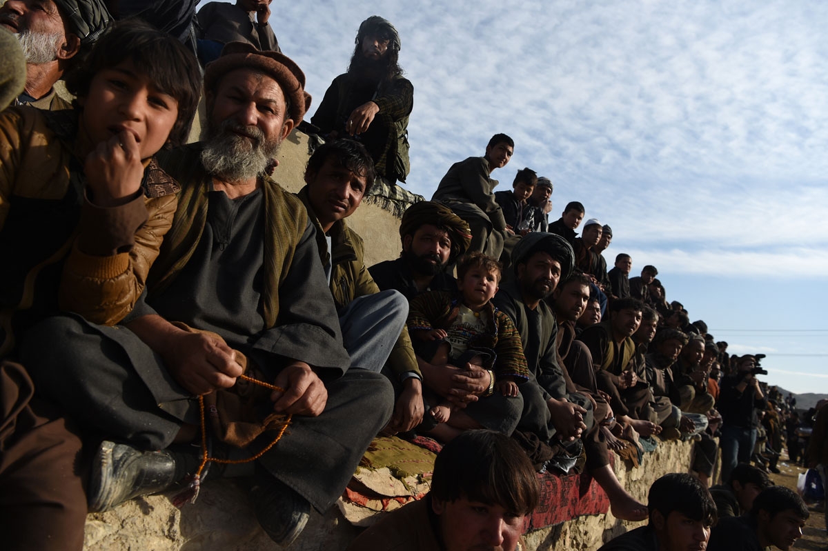 This photo taken on December 1, 2017 shows Afghan spectators watching horsemen compete in the traditional sport of buzkashi on the outskirts of Kabul.