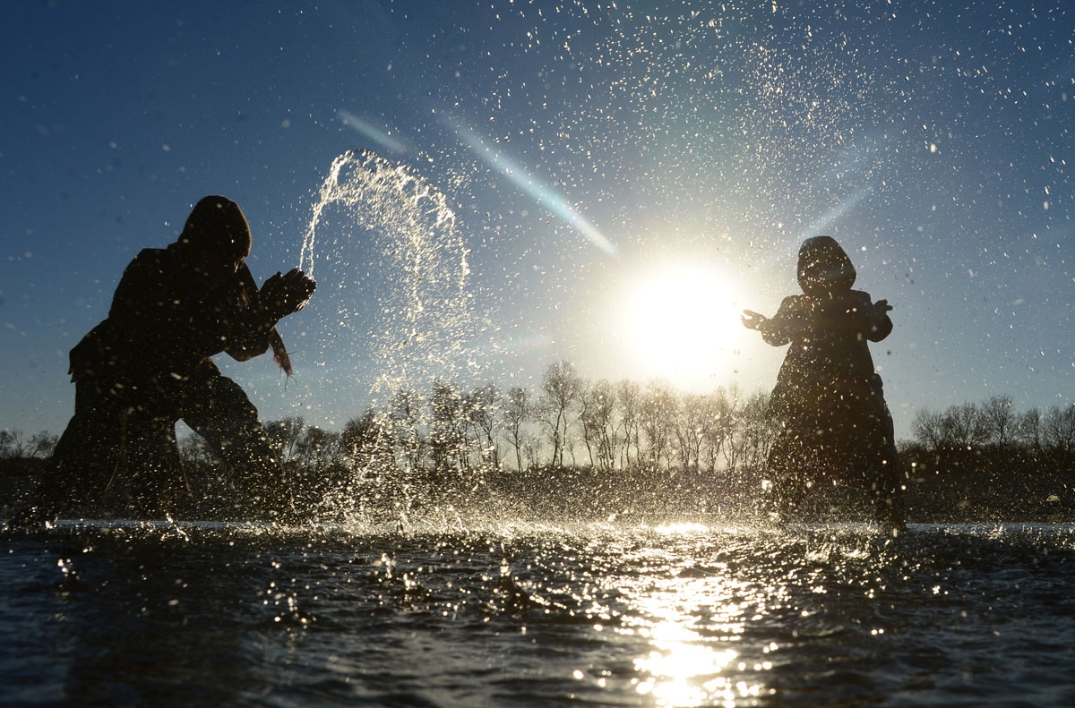 taken on January 9, 2017, Afghan children play at the Heri Rud river in Herat. / AFP PHOTO / AREF KARIMI
