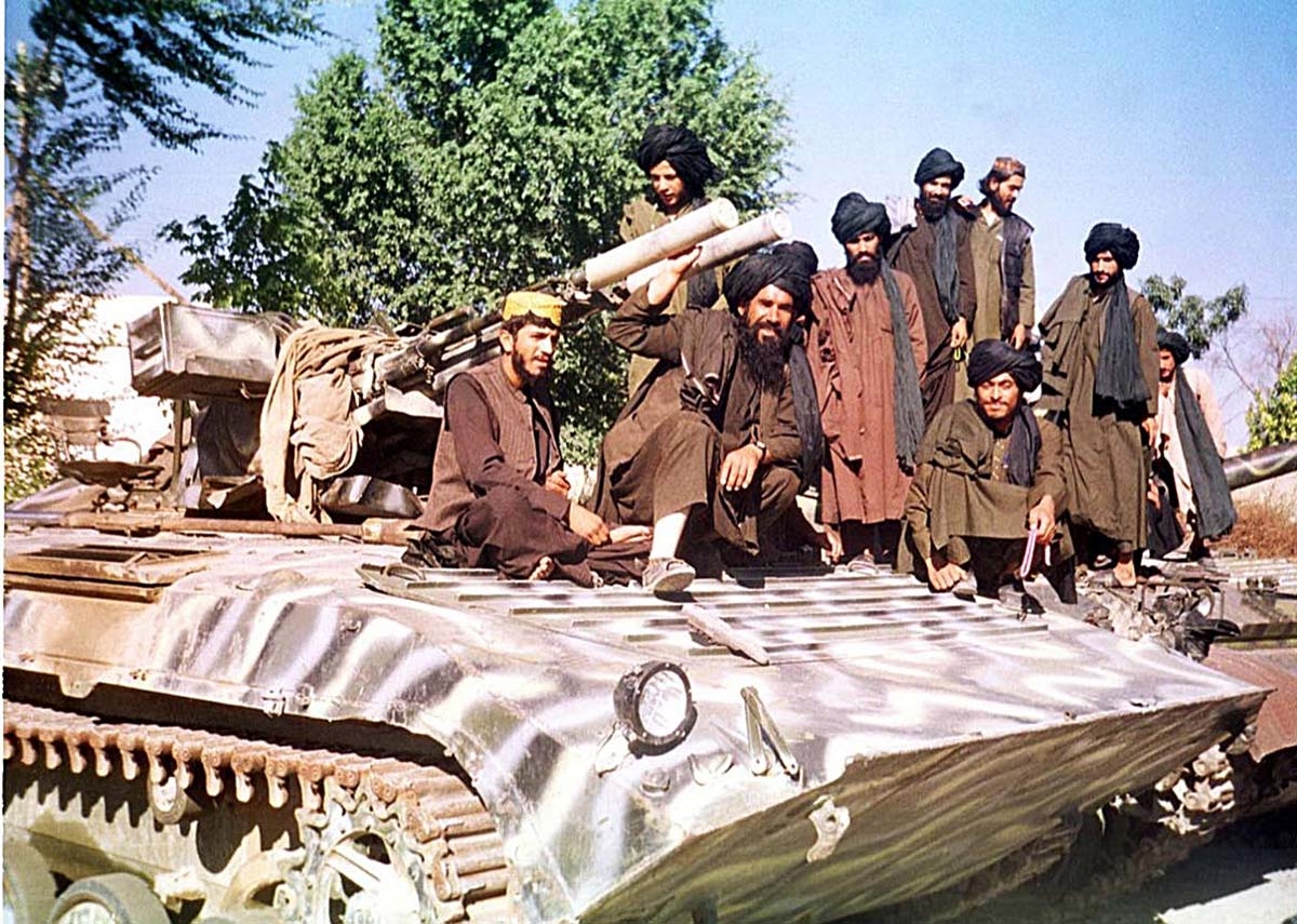 Taliban fighters sit on top of a tank near Kabul 04 October 2001. The Taliban are beefing up security in most parts of the country including Kabul in preparation for defending a US possible assault.