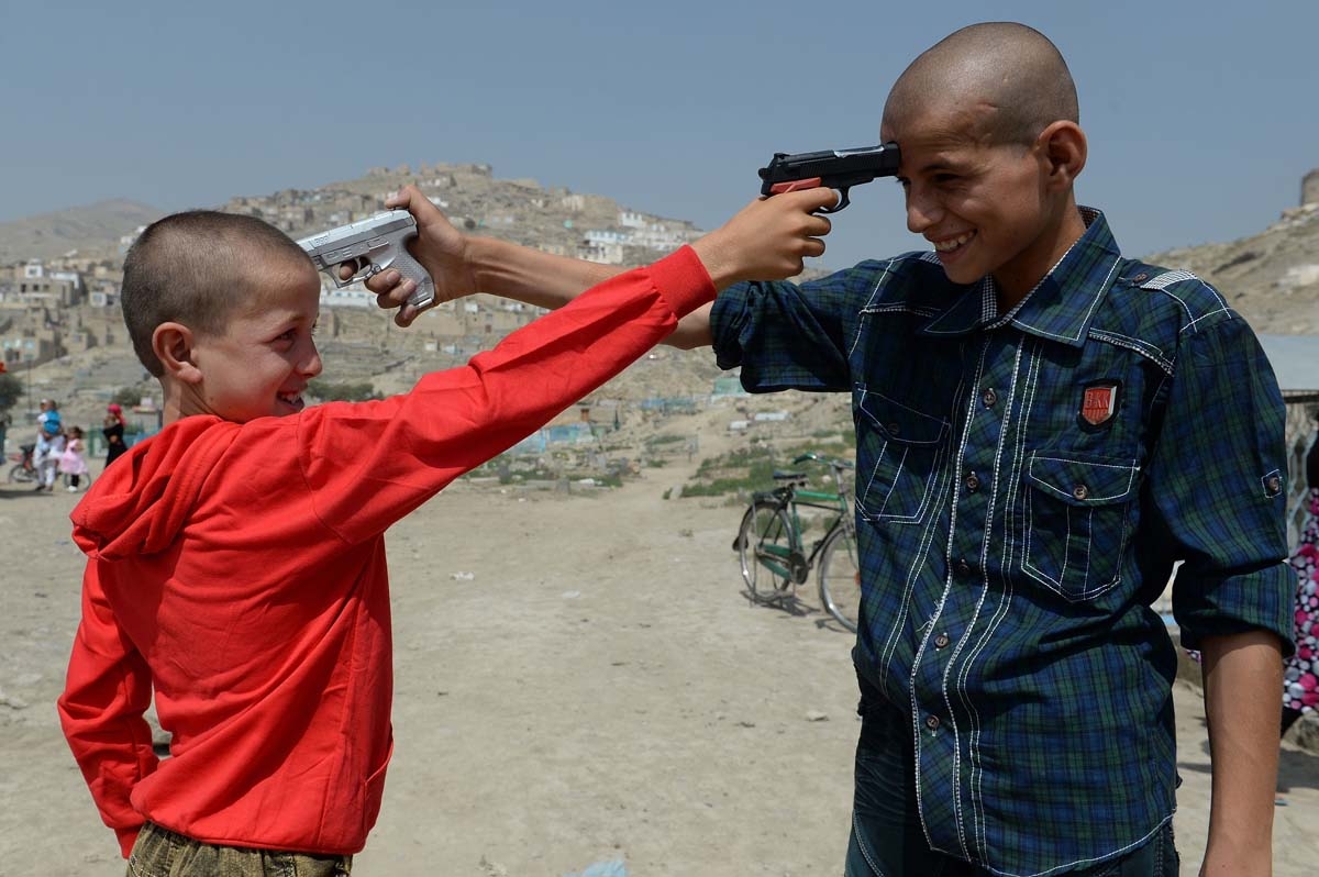 Afghan children play with plastic toy guns in Kabul on August 8, 2013. Civilian casualties in the Afghan war rose 23 percent in the first half of this year due to Taliban attacks and increased fighting between insurgents and government forces, the UN said