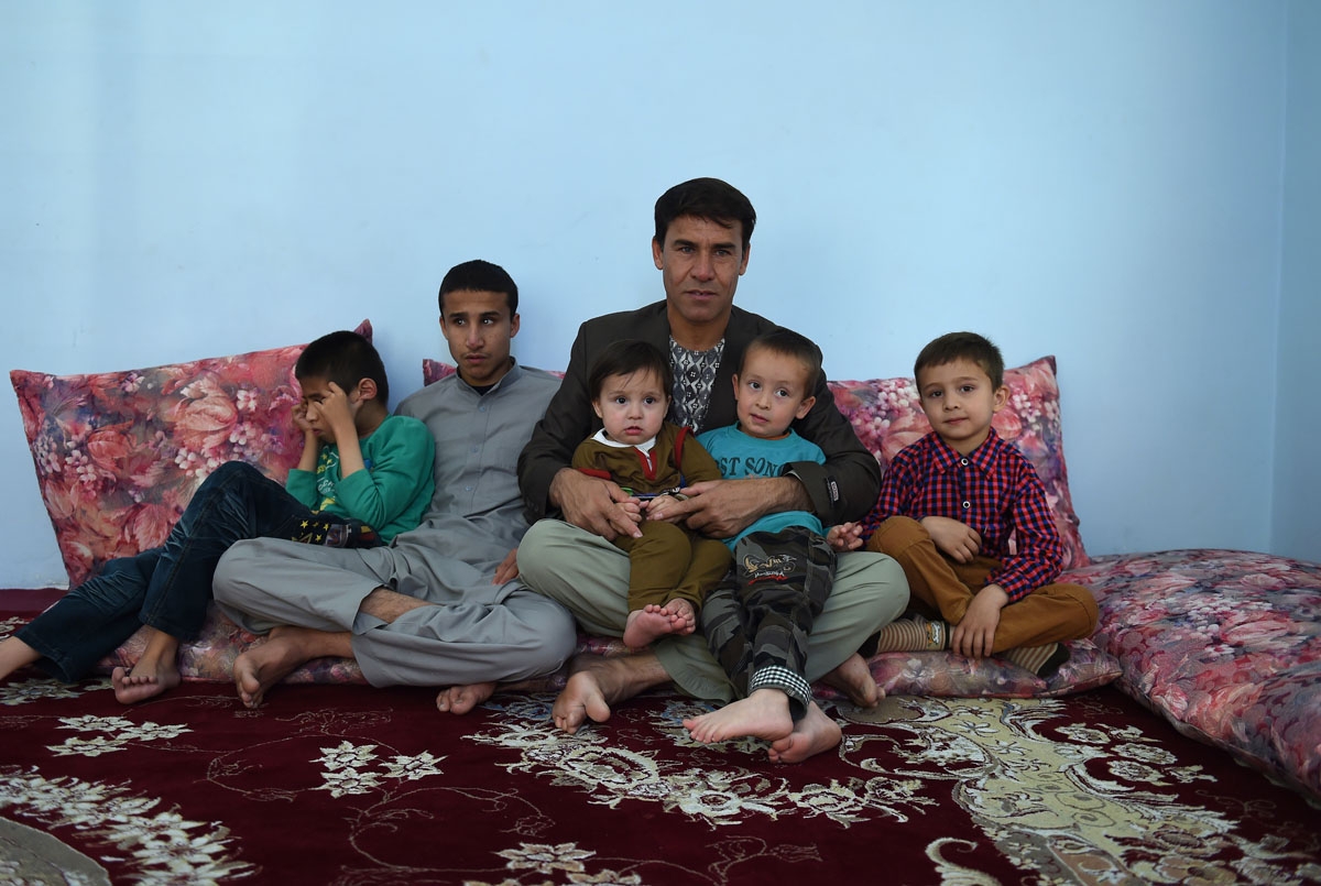 In this photo taken on May 6, 2016, Agence France-Presse (AFP) photographer Shah Marai sits with his children at his home in Kabul.
