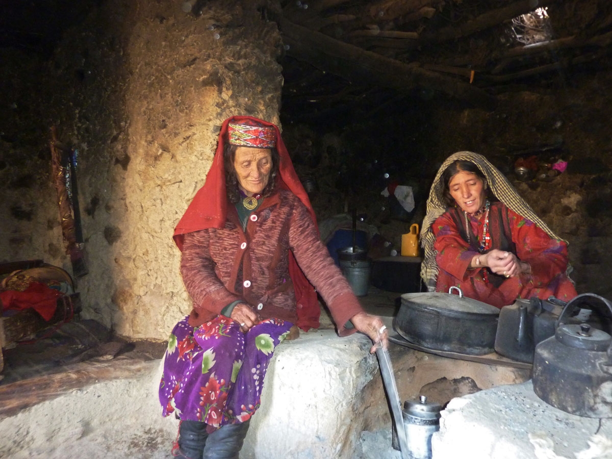 Sultan Begium (L) and her daughter-in-law prepare food inside their mud home.