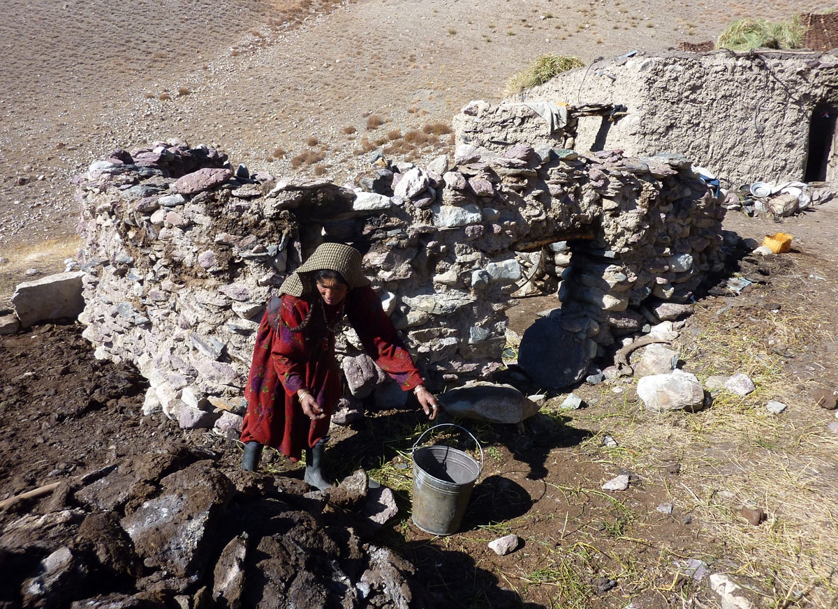 This photograph taken on October 10, 2017 shows Afghan Wakhi nomadic woman Nobot Begium collecting yak dungs that is using for fire fuel outside an animal pen in the Wakhan Corridor in Afghanistan.