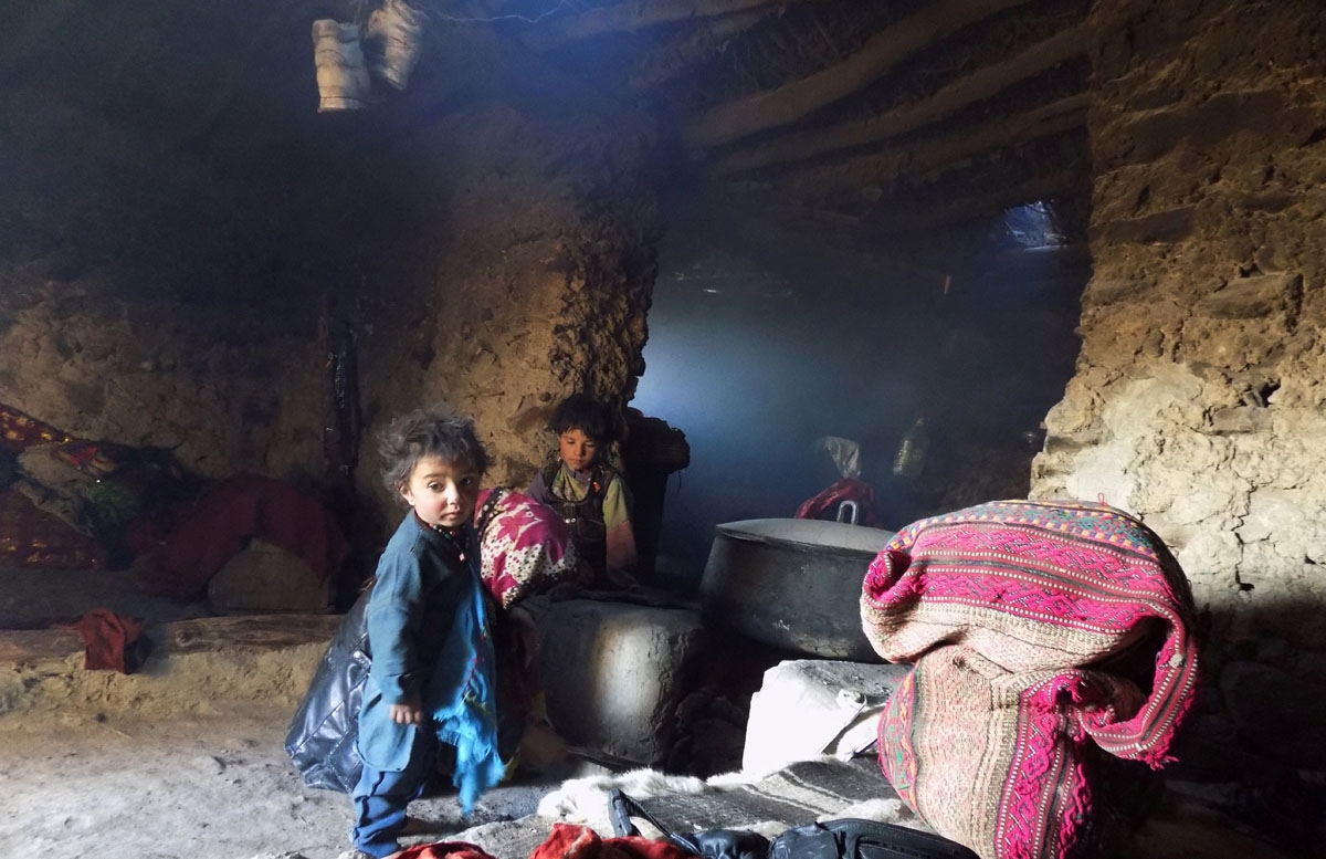 This photograph taken on October 7, 2017 shows Afghan Wakhi nomad children by a stove inside their mud home in the Wakhan Corridor in Afghanistan.