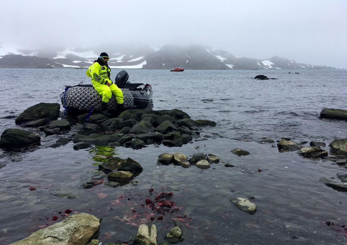 A zodiac driver waits on his boat, on the coast of King George Island, Antarctica on February 3, 2018.