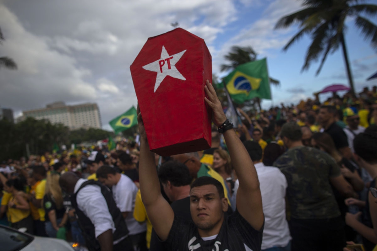 A supporter of far-right lawmaker and presidential candidate for the Social Liberal Party (PSL), Jair Bolsonaro, holds a coffin representing the Workers Party (PT) during a demonstration in Rio de Janeiro, Brazil, during the second round of the presidenti