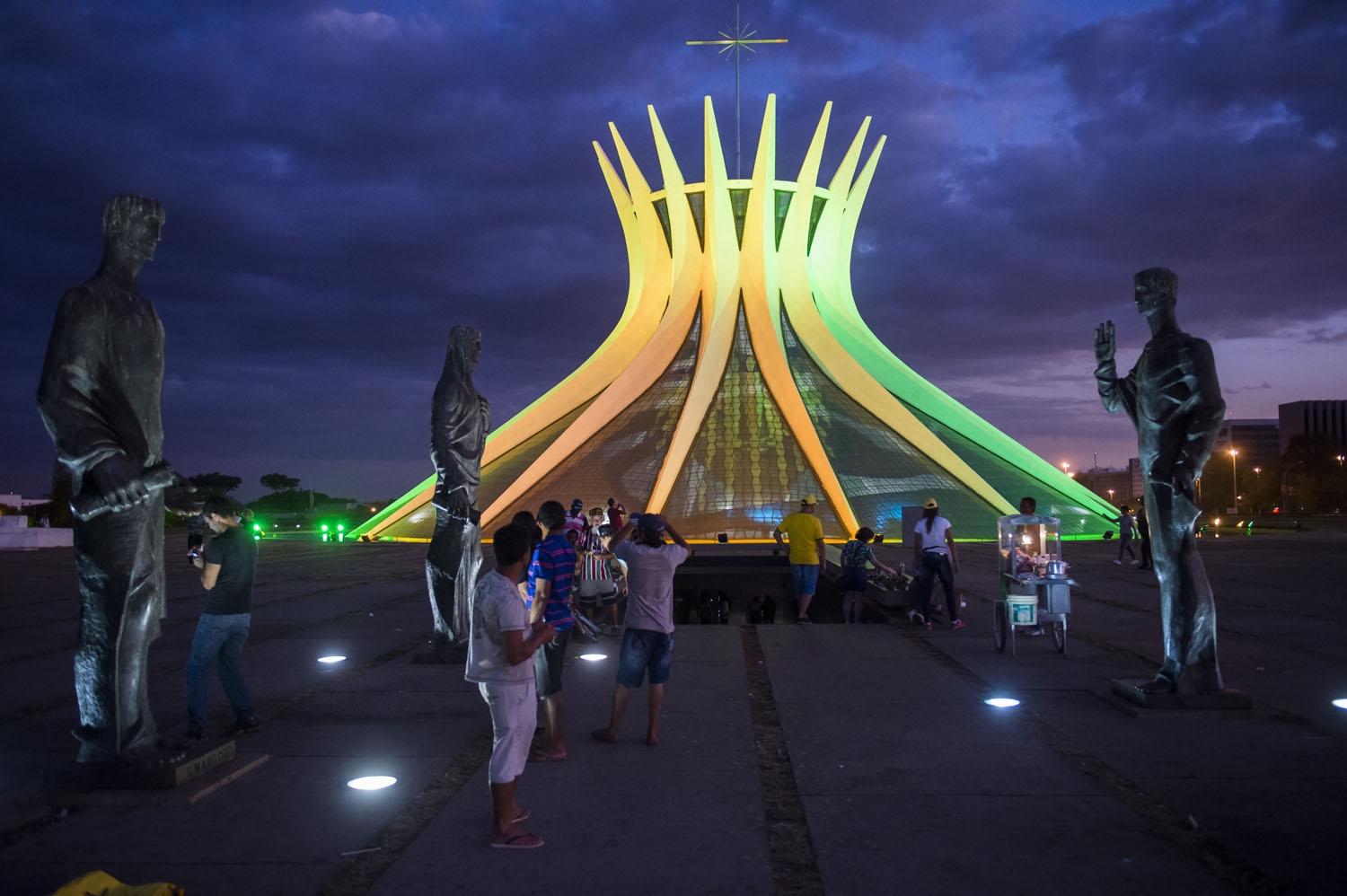 Tourists are seen among the bronze statues of the four evangelists in front of the Cathedral in Brasilia on June 30, 2014 Tourists are seen among the bronze statues of the four evangelists in front of the Cathedral in Brasilia on June 30, 2014