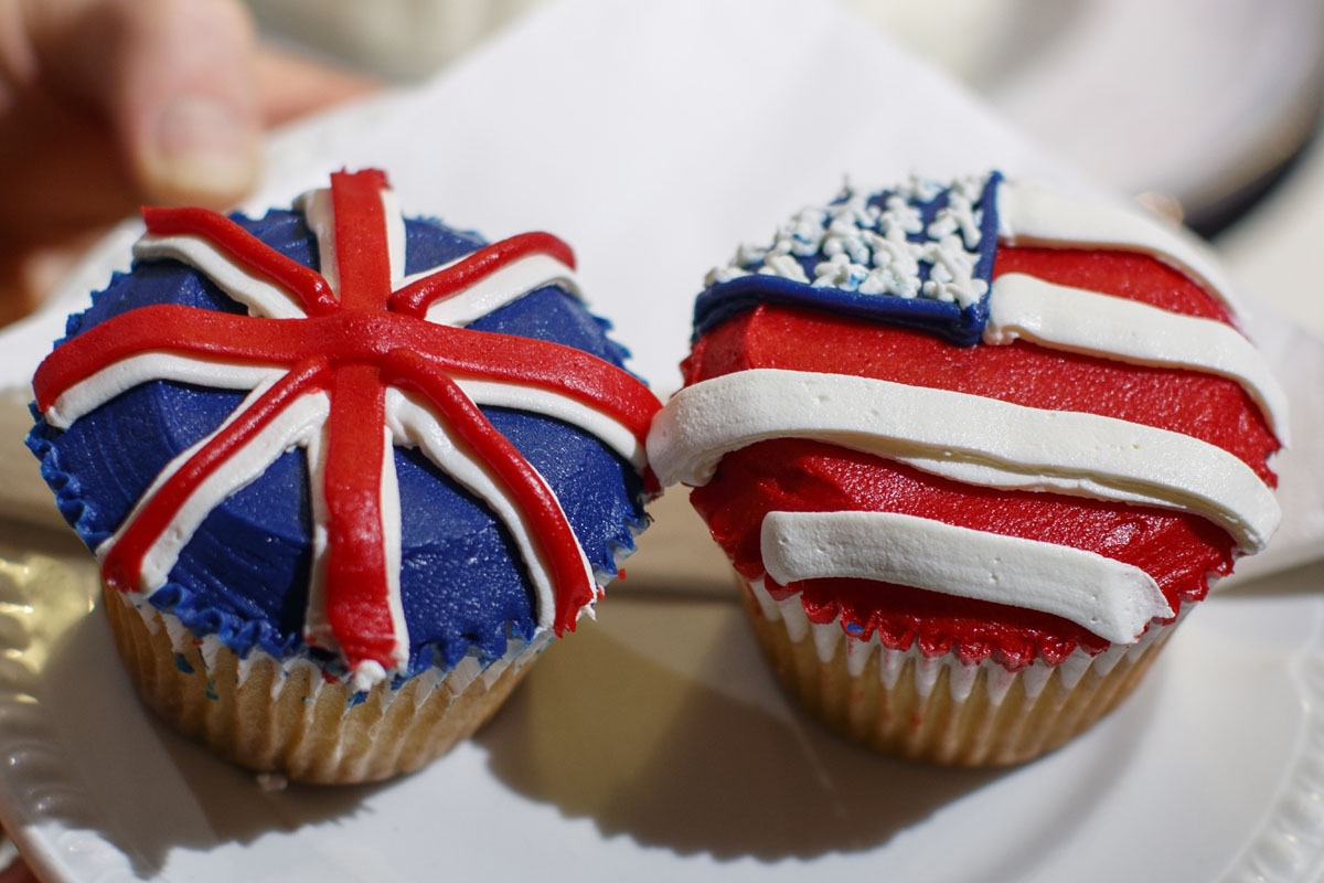 A member of staff at the Hummingbird Bakery poses with cupcakes themed with icing depicting the Union Flag and the US flag to mark the upcoming Royal Wedding of Prince Harry and US actress Meghan Markle in central London on May 11, 2018.
