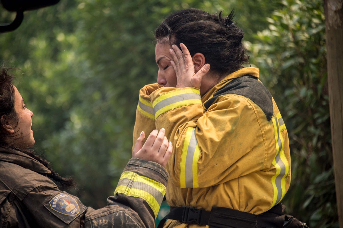 A firefighter mourns the loss of a colleague during a forest fire in the coastal resort of Llico, 276 kilometres south of Santiago on January 26, 2017.