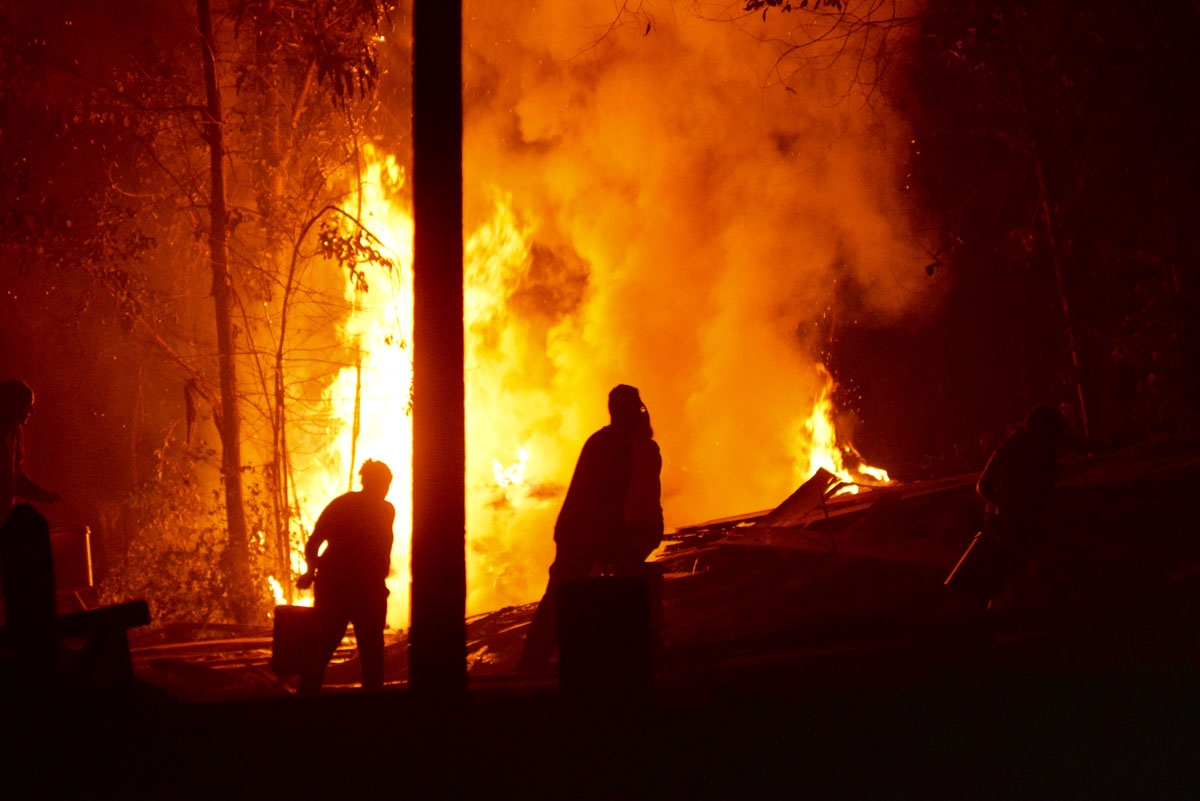 People work to put out a forest fire in Hualqui, 30 kilometres south of Concepcion, Biobio region, Chile on January 27, 2017.