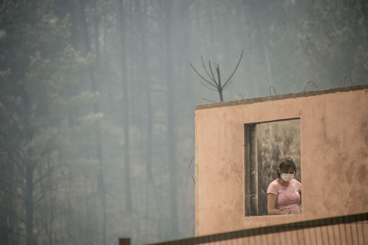 Volunteers work to clean up the debris in Santa Olga, 350 kilometres south of Santiago, after the town was devastated by a forest fire on January 27, 2017