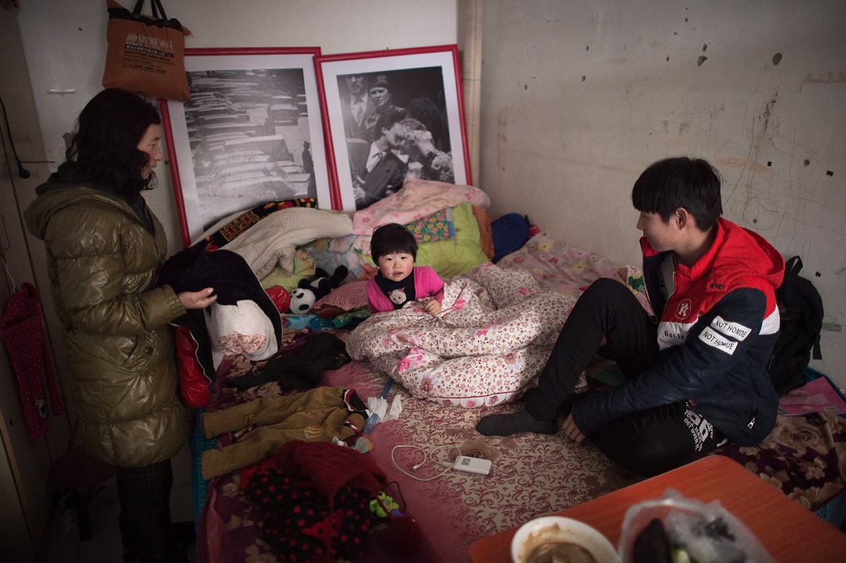 This picture taken on January 18, 2017 shows a family inside their tiny shared room in the Heiqiaocun migrant village in Beijing.