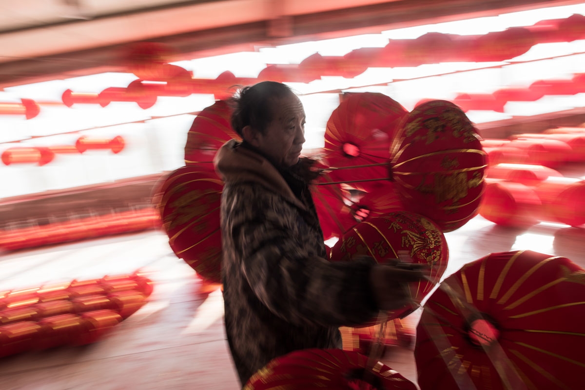 In this picture taken on January 11, 2018 a Chinese worker carries red lanterns for the upcoming Lunar New Year celebrations on February 15, at a factory in the village of Tuntou, in Hebei province southwest of Beijing.