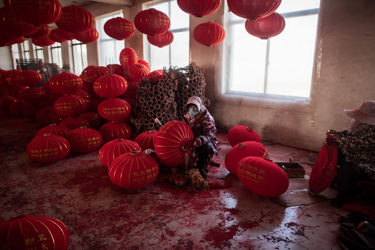 In this picture taken on January 11, 2018 a Chinese worker makes red lanterns ahead of the upcoming Lunar New Year celebrations on February 15, at a factory in the village of Tuntou in Hebei province southwest of Beijing.