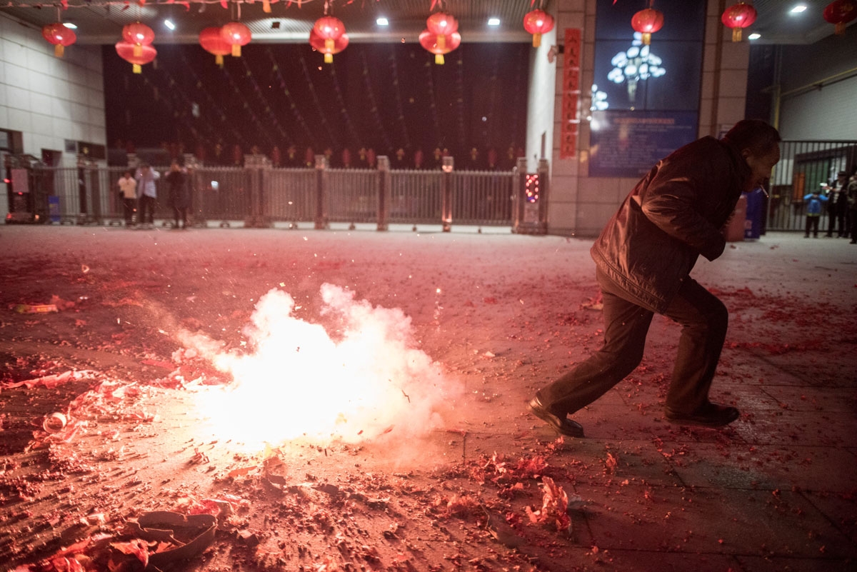People light fireworks after midnight to celebrate the Lunar New Year, marking the Year of the Dog, in Hancheng, Shaanxi province, on February 16, 2018.