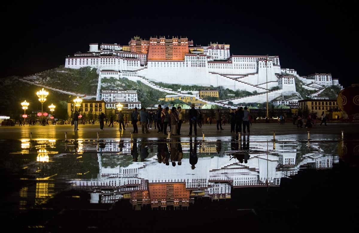 This picture taken on September 9, 2016 shows tourists in front of the iconic Potala Palace in the regional capital Lhasa, in China's Tibet Autonomous Region. This picture taken on September 9, 2016 shows tourists in front of the iconic Potala Palace in the regional capital Lhasa, in China's Tibet Autonomous Region.