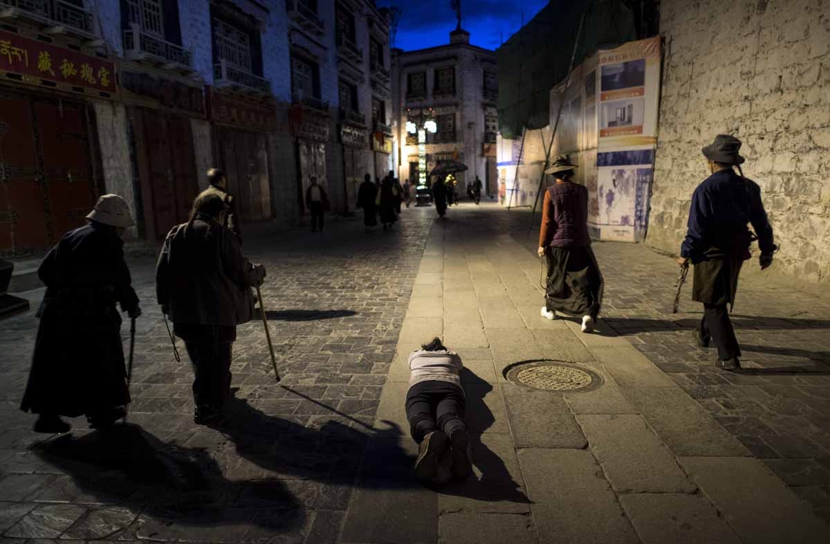 This picture taken on September 11, 2016 shows a pilgrim praying and prostrating outside the Jokhang Temple in the regional capital Lhasa, in China's Tibet Autonomous Region. This picture taken on September 11, 2016 shows a pilgrim praying and prostrating outside the Jokhang Temple in the regional capital Lhasa, in China's Tibet Autonomous Region.