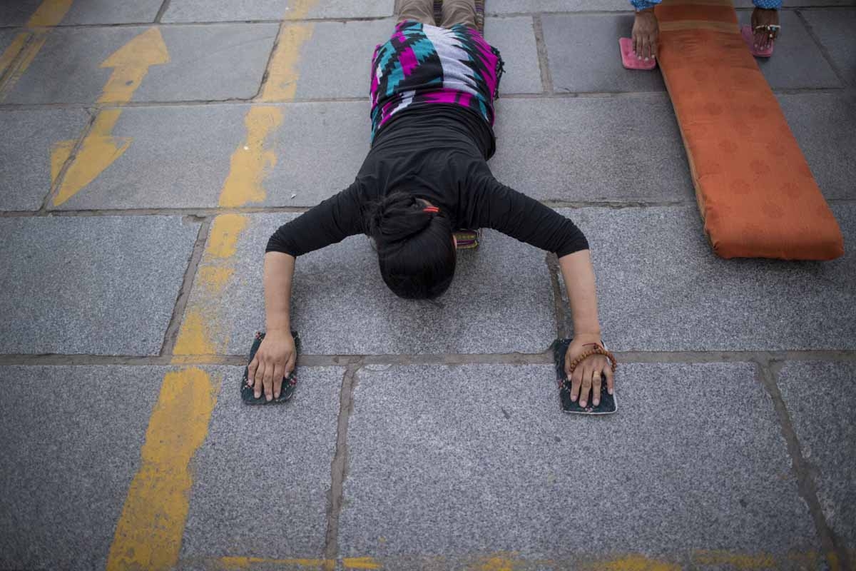This picture taken on September 10, 2016 shows a pilgrim praying and prostrating outside the Jokhang Temple in the regional capital Lhasa, in China's Tibet Autonomous Region. This picture taken on September 10, 2016 shows a pilgrim praying and prostrating outside the Jokhang Temple in the regional capital Lhasa, in China's Tibet Autonomous Region.