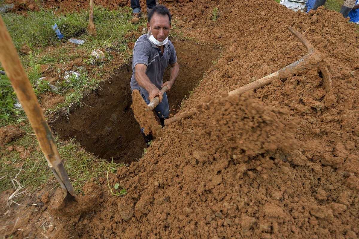 A man digs a grave of a relative killed by mudslides caused by heavy rains, at the cemetery in Mocoa, Putumayo department, Colombia on April 3, 2017.