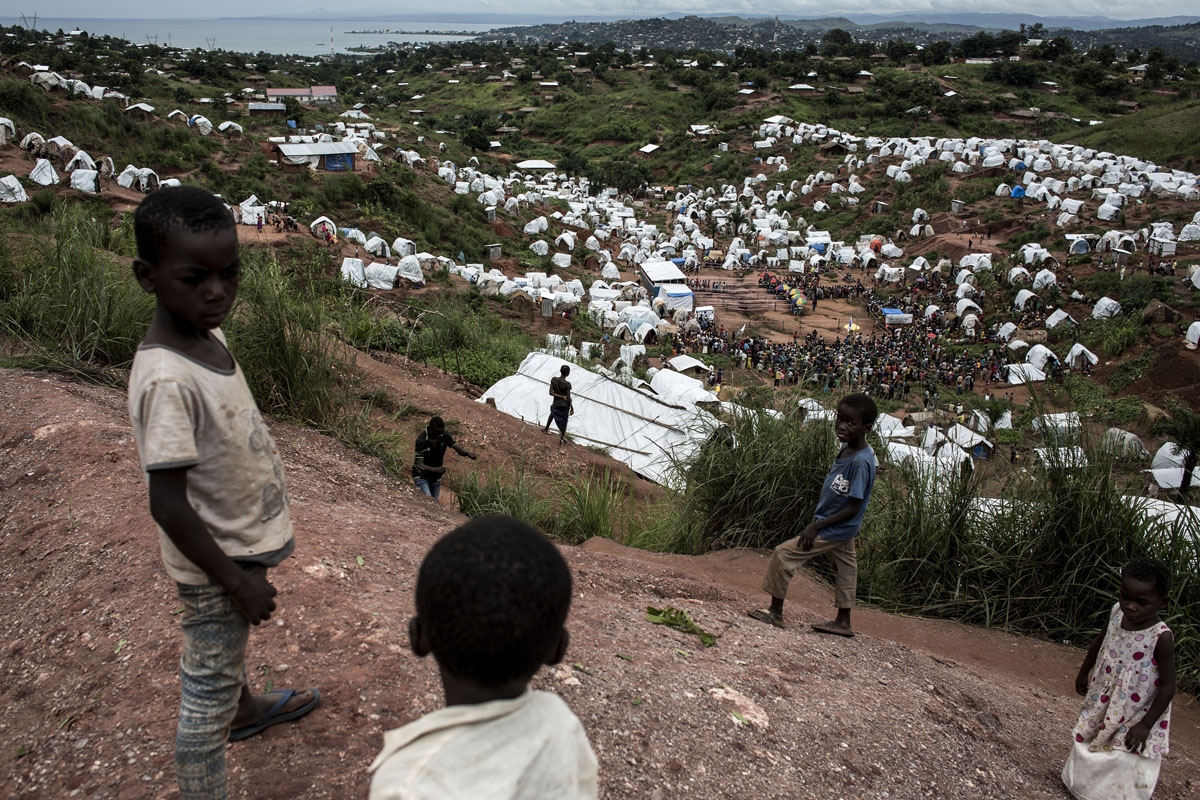Young Congolese are seen on a hilltop look out over a camp for Internally Displaced Persons (IDP) on March 20, 2018 in Kalemie, Democratic Republic of the Congo.