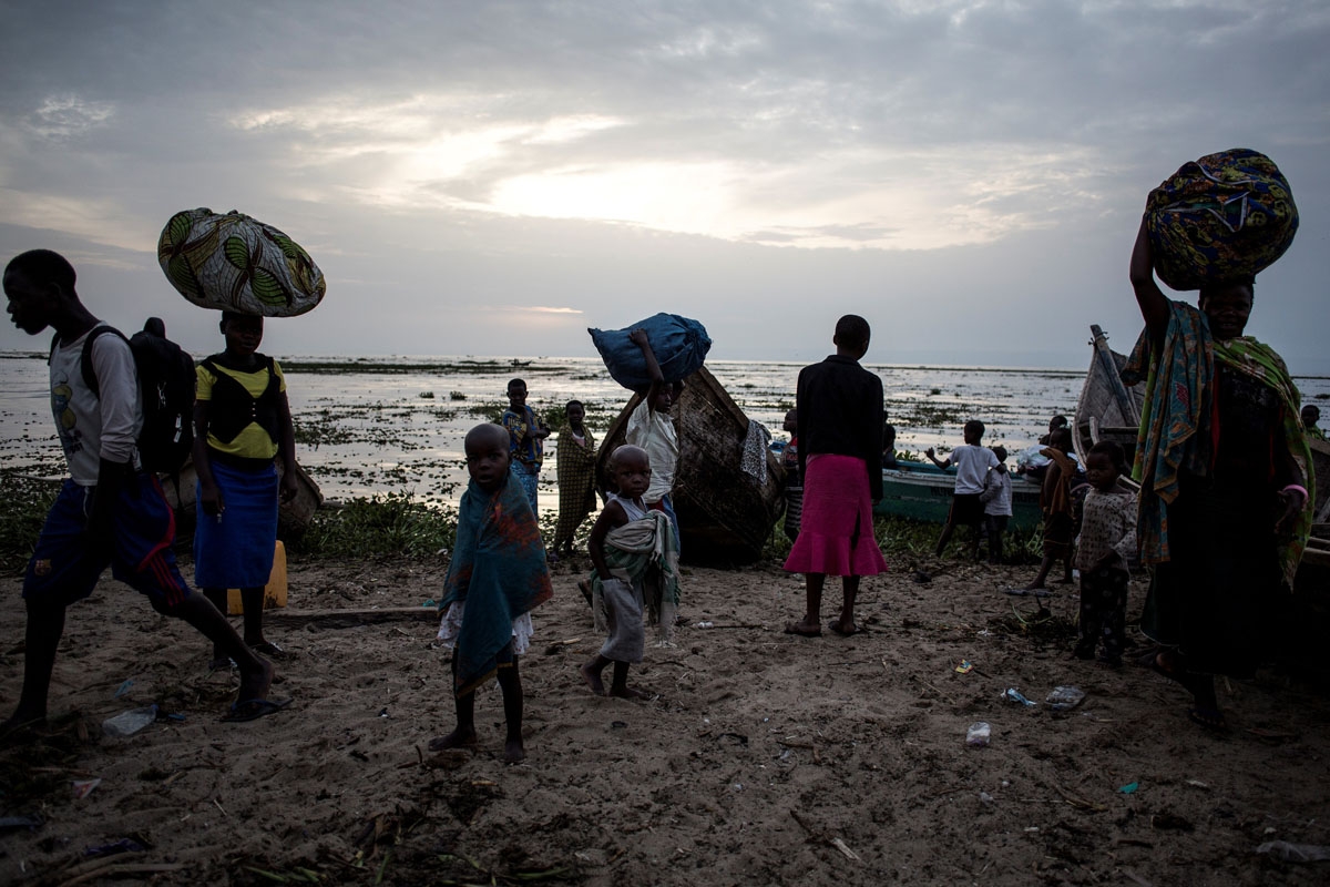 Internally displaced Congolese return to the shore line of Lake Albert after spending the night out in the lake for safety on March 5, 2018 in Tchomia.