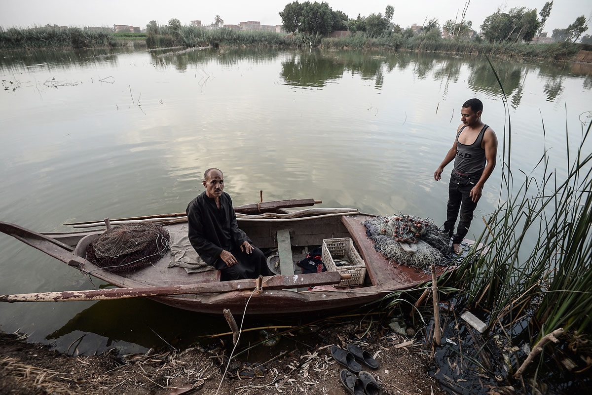 An Egyptian Fisherman sits on his boat in the Pharaonic Sea, in the village of Kafr Fisha, province of Munuf, on June 16, 2018. The Pharaonic Sea is the name of a large water body in the province of Menoufia, an area of 2500 acres and overlooking 50 villa