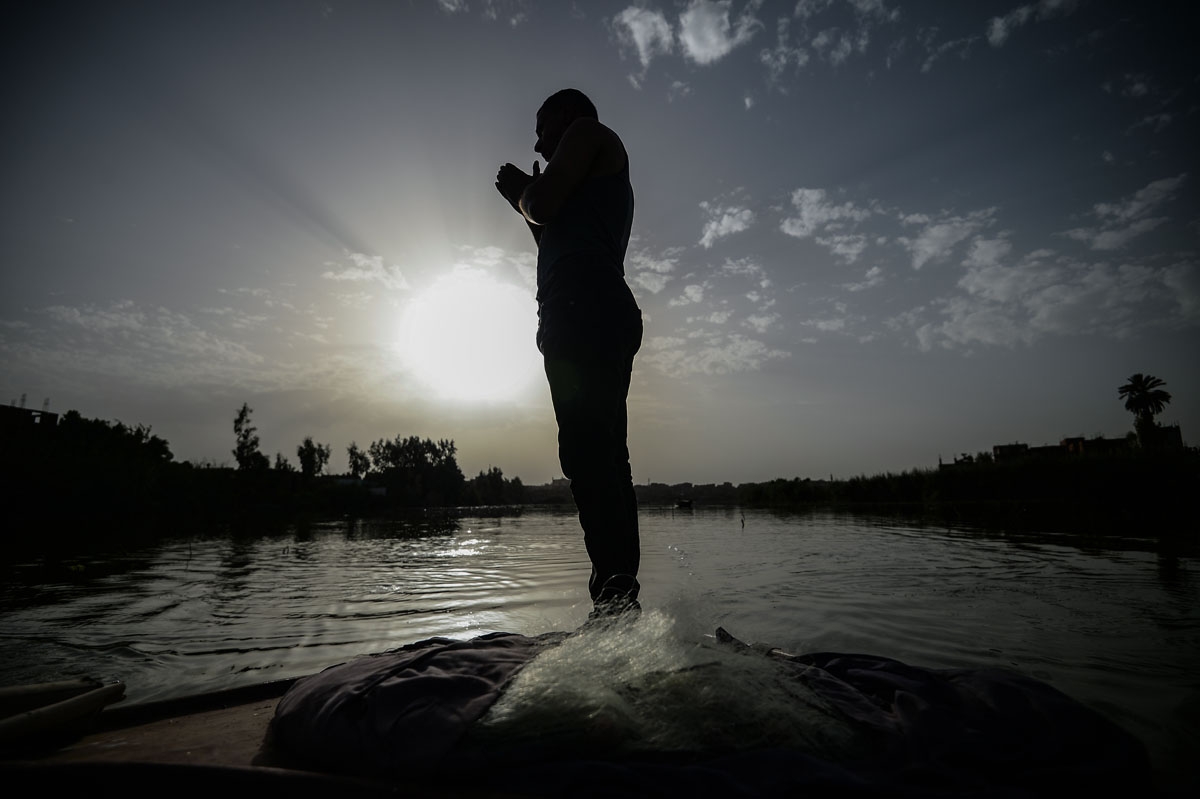 An Egyptian Fisherman prays on his boat in the waters of the Pharaonic Sea in the village of Kafr Fisha, province of Munuf, on June 16, 2018.