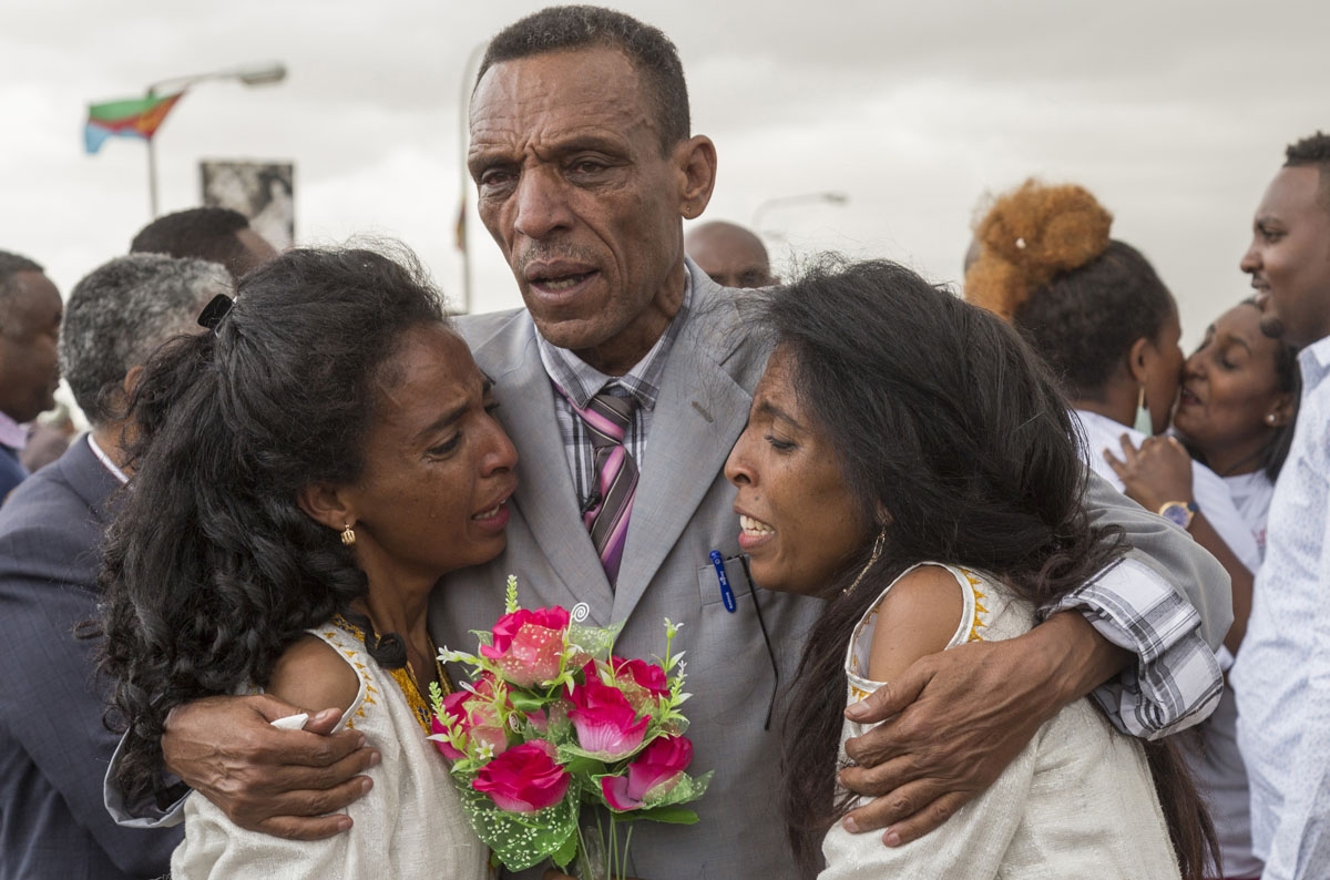 Azmera Addisalem and Danait Addisalem cry and hug their father, an Ethiopian journalist, at Asmara International airport on July 21, 2018, as they are reunited for the first time since twenty years, when the war broke out between Ethiopia and Eritrea in 1