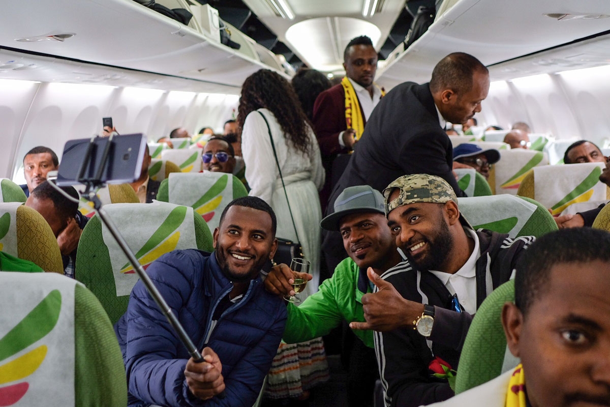 Passengers pose for a selfie picture inside an Ethiopian Airlines flight who departed from the Bole International Airport in Addis Ababa, Ethiopia, to Eritrea's capital Asmara on July 18, 2018.