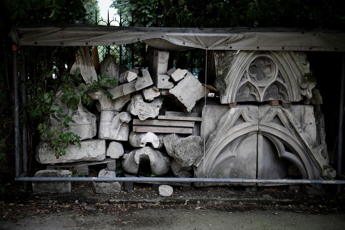 A picture taken on June 28, 2017 shows remains of Notre-Dame cathedral in Paris, stored in a garden, as the monument needs a huge restoration.