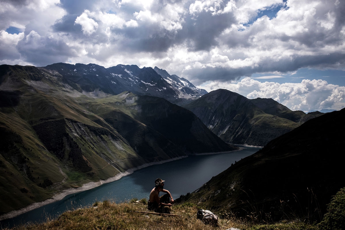 French shepherd Gaetan Meme, 24-years-old, looks over a flock of sheep near the Lac de Grand Maison (Grand Maison lake), on August 21, 2018, along the Alpine pastures in the mountains near the Col du Glandon, in the French Alps. - Gaetan shepherds a flock