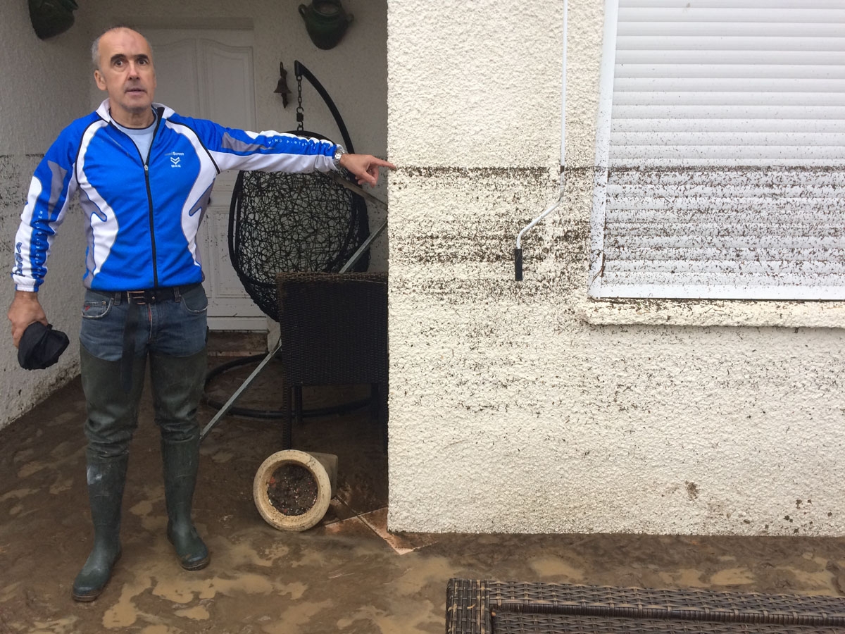 A resident shows on a house the level reached by water during floods on October 15, 2018 in Villegailhenc, near Carcassone, southern France. - Six people died following storm and flash floods during the night of October 15 in the Aude department in southe