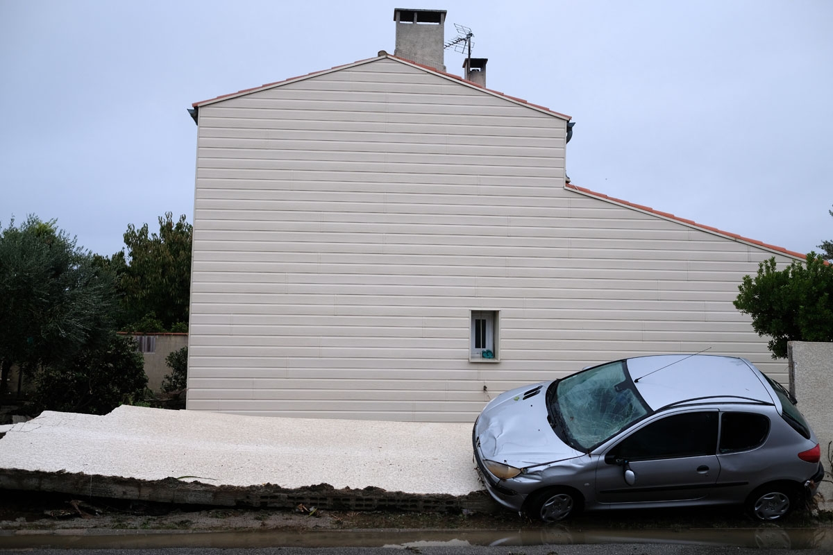 A damaged car is pictured in a flooded street of Villegailhenc in the Aude department after it was particularly badly hit by heavy rain storms which swamped parts of southwestern France, flooding rivers and cutting roads, killing at least six people. - Th