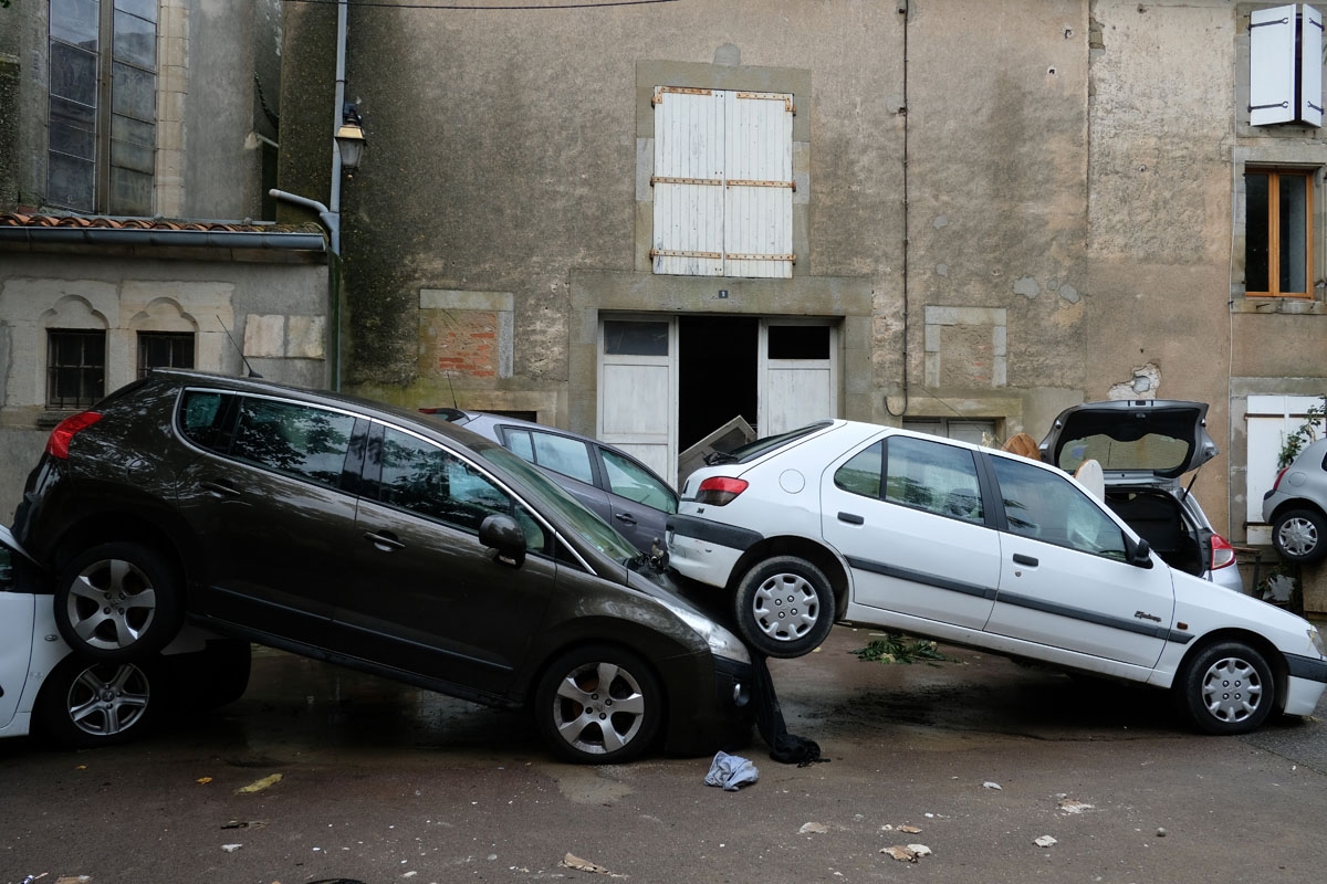 A photo taken on October 15, 2018 shows damaged cars piled up on the streets following heavy rains that saw rivers bursting banks in Villegailhenc, near Carcassone, southern France. -