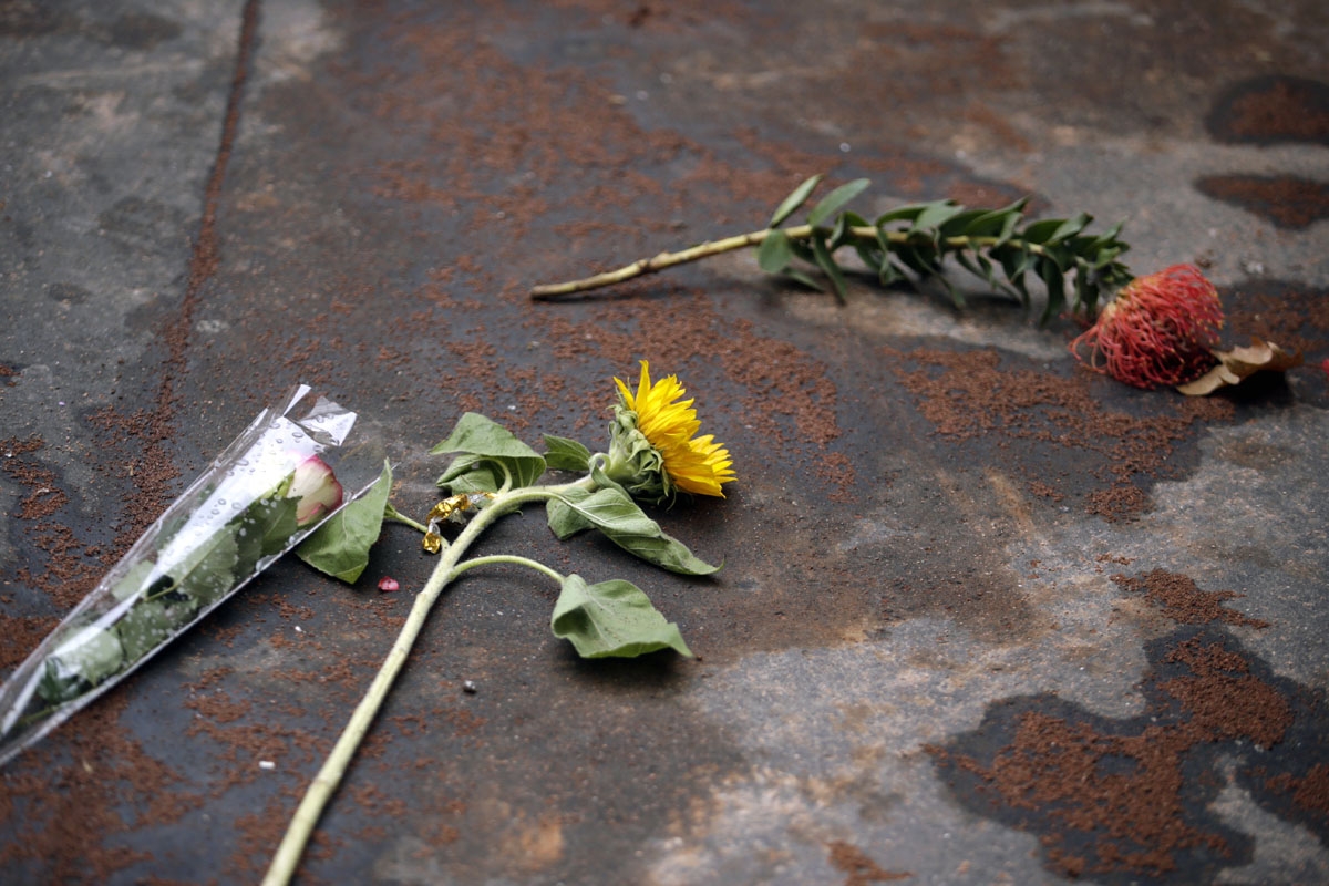 Flowers are put on the sand covering bloodstains on the ground on November 17, 2015, near the the cafe A la Bonne Biere and restaurant Casa Nostra, at one of the sites of terror attacks claimed by Islamic State which killed at least 129 people and left mo