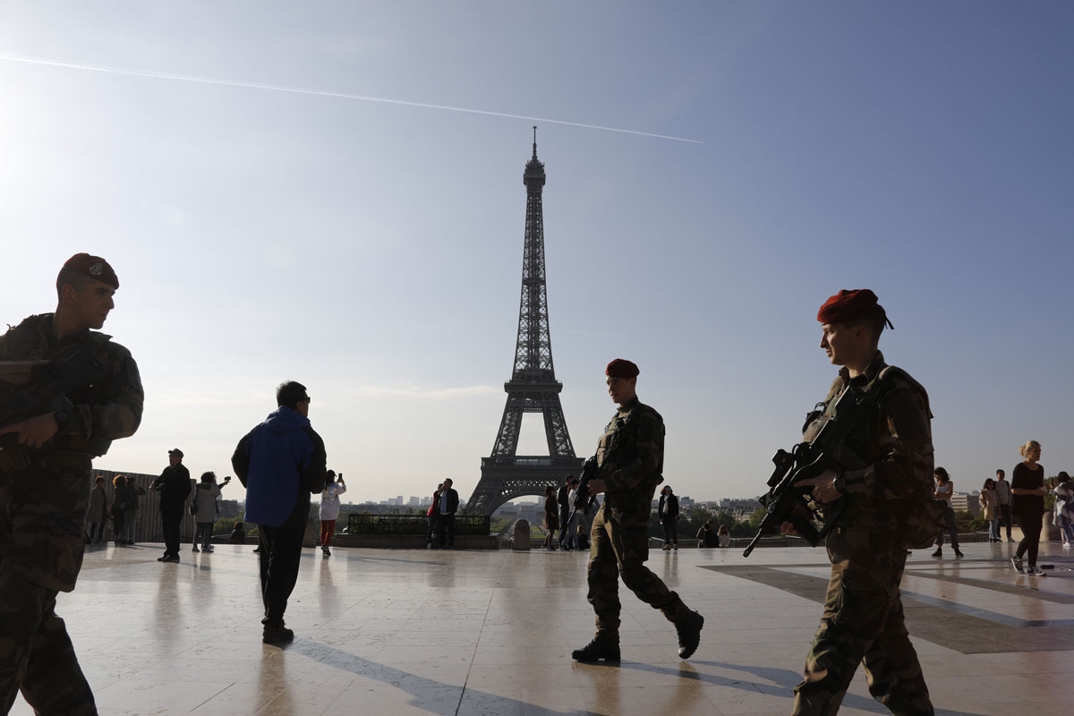 French soldiers of the Operation Sentinelle patrol on the Human Right square in front of the Eiffel tower in Paris, on April 23, 2017, as France vote for the first round of the presidential election.