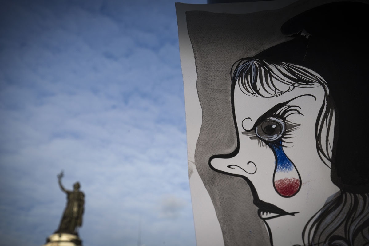 A picture taken on November 22, 2015 shows a painting by French painter and graphic designer Liox picturing Marianne, the allegoric symbol of French Republic, in front of the Republic statue in Paris in tribute to the victims of November 13 attacks in Par