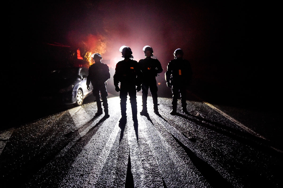 French riot police officers stand guard during the eviction of environmental protesters from the site, known as ZAD (Zone a Defendre - Zone to defend) of what had been a proposed new airport in Notre dame des Landes on April 9, 2018.