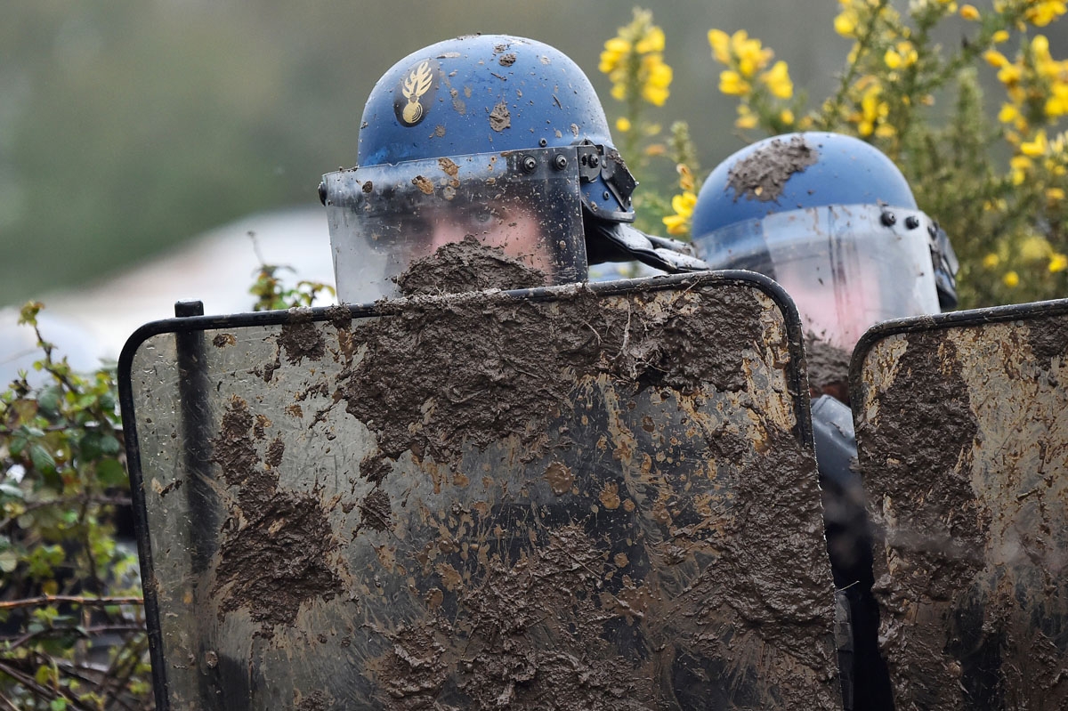 French gendarmes gather behind riot shields as they clash with ZAD activists to clear an area known as ZAD (Zone a Defendre - Zone to defend) of environmental protesters occupying the site of what had been a proposed new airport in Notre dame des Landes