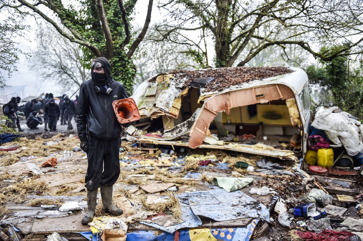 A protester stands in the rubble destroyed houses on April 10, 2018 during a police operation to raze the decade-old camp known as ZAD (Zone a Defendre - Zone to defend) at Notre-Dame-des-Landes, near the western city of Nantes, and evict the last of the