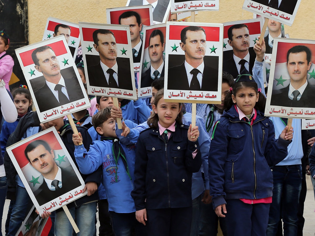 Syrian children hold portraits of President Bashar al-Assad during a gathering in support the ruling Baath party at a school in the government-held side of the northern city of Aleppo on November 17, 2014. Syrian children hold portraits of President Bashar al-Assad during a gathering in support the ruling Baath party at a school in the government-held side of the northern city of Aleppo on November 17, 2014.