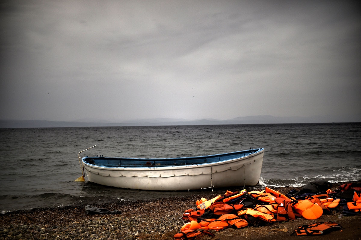 Life jackets and a boat that were used by refugees and migrants to cross the Aegean sea from Turkey lie abandoned on a beach on the Greek Island of Lesbos on October 8, 2015. Life jackets and a boat that were used by refugees and migrants to cross the Aegean sea from Turkey lie abandoned on a beach on the Greek Island of Lesbos on October 8, 2015.