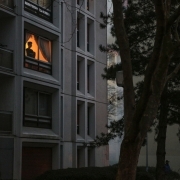 A person looks through an apartment window as anti riot police clashes with demonstrators in Bobigny, northern Paris, on February 16, 2017 during a demonstration to demand justice for Theo, a 22-year-old youth worker who required surgery after his arrest