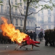 Protesters push a burning trolley towards French CRS anti-riot police officers during a march for the annual May Day workers' rally in Paris on May 1, 2017.