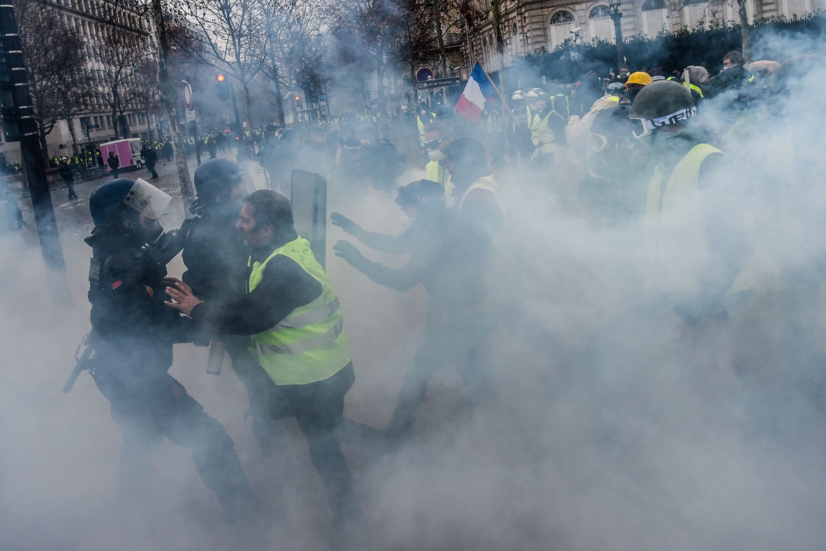 Demonstrators clash with riot police on the Champs Elysees avenue in Paris during a protest of Yellow vests (Gilets jaunes) against rising oil prices and living costs, on December 1, 2018. - Thousands of anti-government protesters are expected today on th