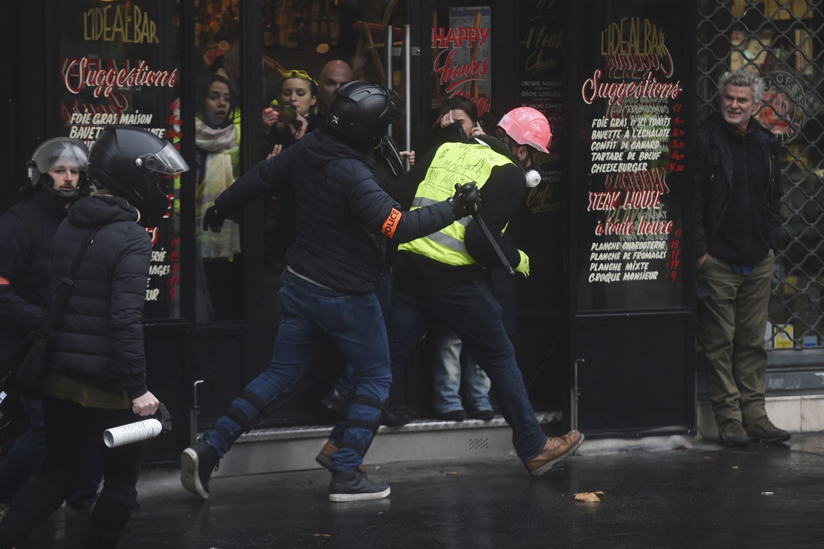 Riot police officers clash with demonstrator during a protest of Yellow vests (Gilets jaunes) against rising oil prices and living costs, on December 1, 2018 in Paris.