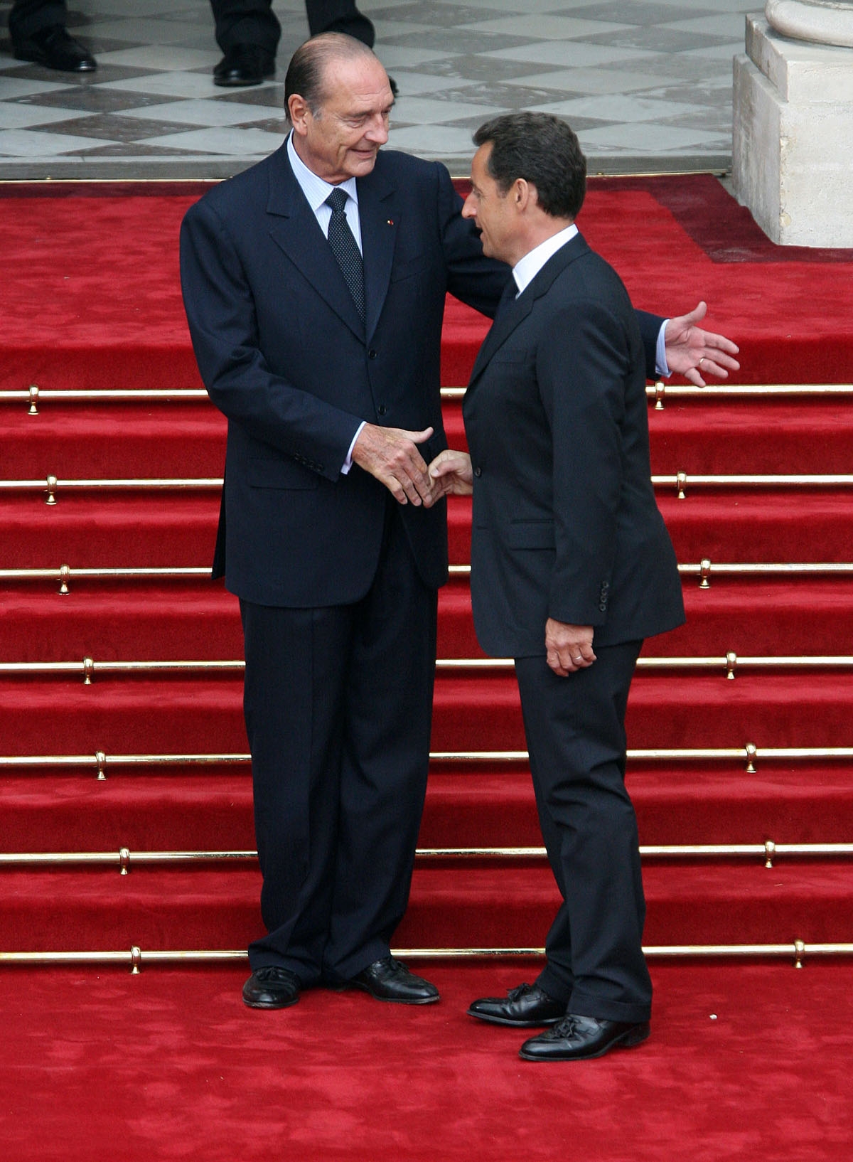 French president Jacques Chirac (L) welcomes his successor Nicolas Sarkozy upon his arrival at the Elysee Palace for the formal handover of power ceremony, 16 May 2007 in Paris.