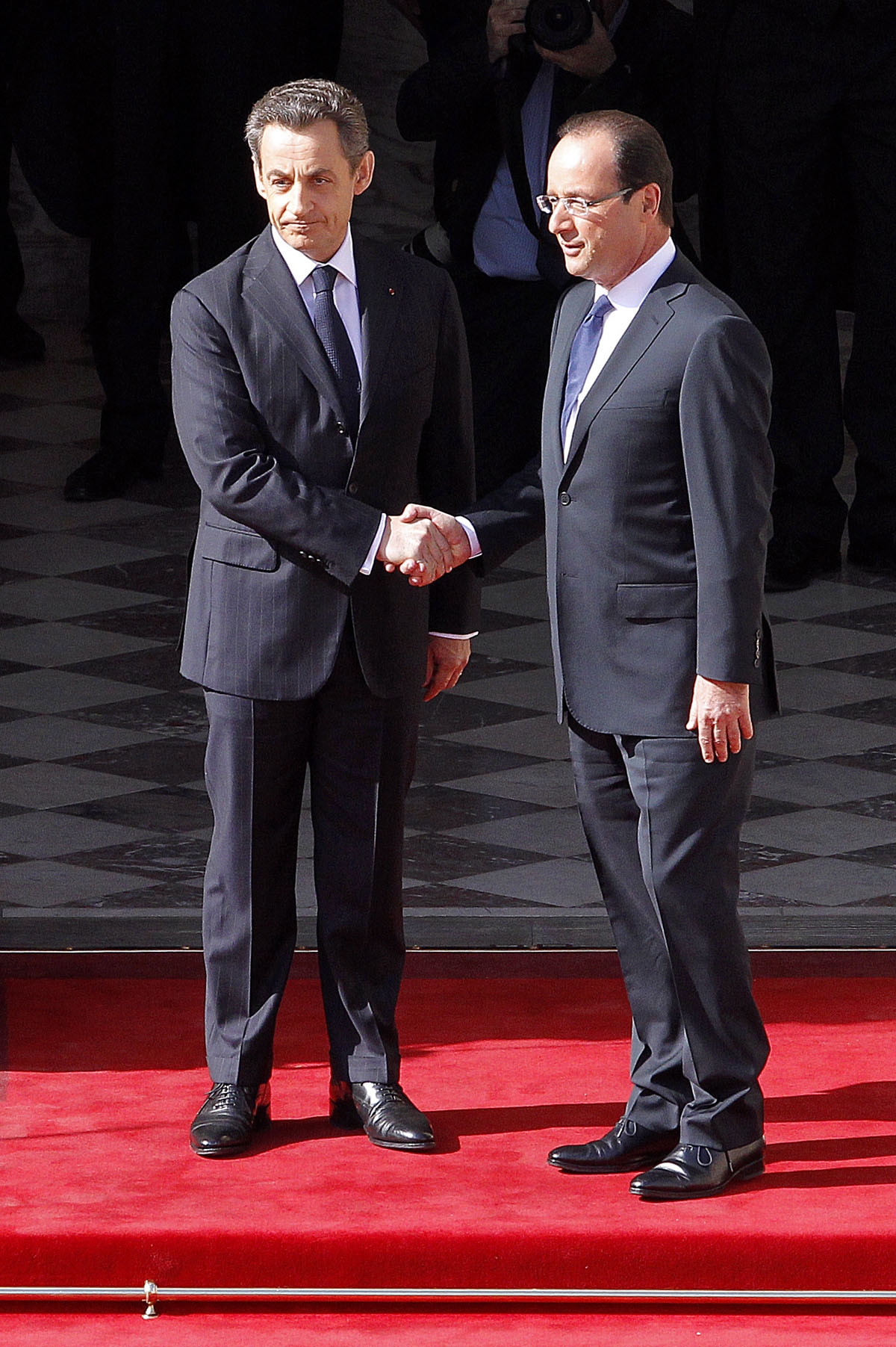 France's President Francois Hollande (R) shakes hands with his predecessor Nicolas Sarkozy (L) prior to the start of the investiture ceremony on May 15, 2012 at the presidential Elysee Palace in Paris.