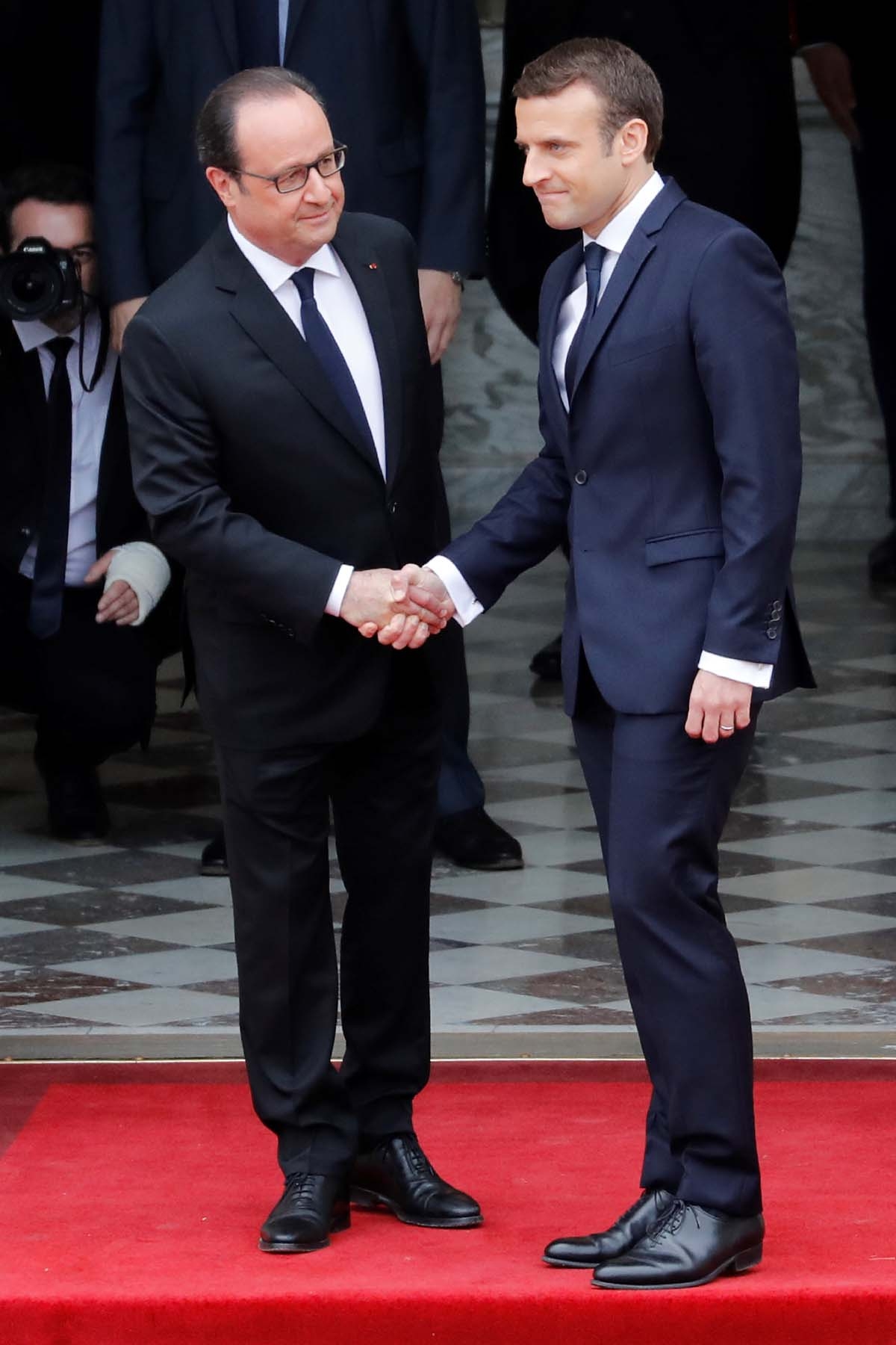 French newly elected President Emmanuel Macron (R) is welcomed by his predecessor Francois Hollande as he arrives at the Elysee presidential Palace for the handover and inauguration ceremonies on May 14, 2017 in Paris.
