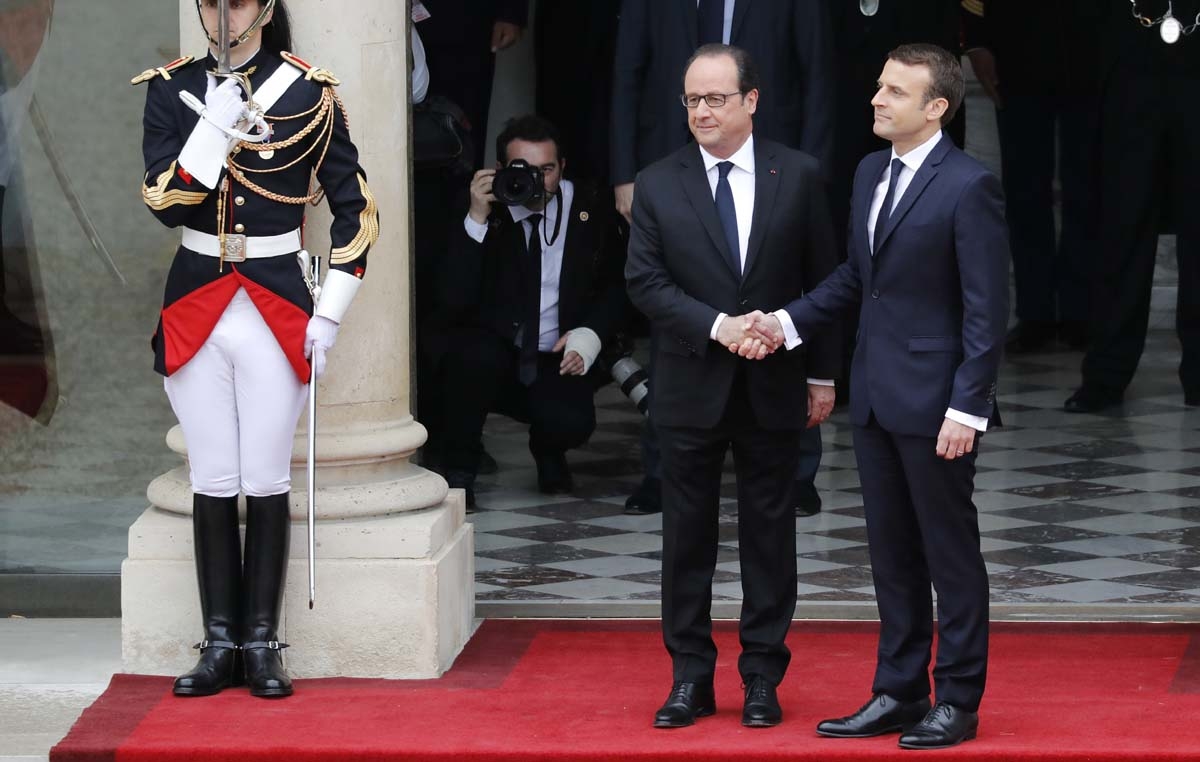 French newly elected President Emmanuel Macron (R) is welcomed by his predecessor Francois Hollande as he arrives at the Elysee presidential Palace for the handover and inauguration ceremonies on May 14, 2017 in Paris.